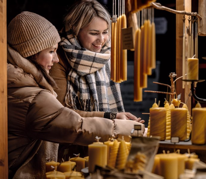 Foto van twee vrouwen die kaarsen kopen op de kerstmarkt in Oldenburg