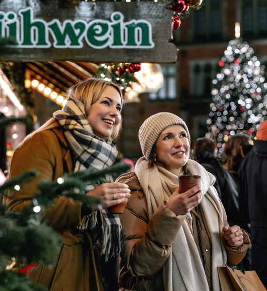 Foto van twee vrouwen die glühwein drinken op de kerstmarkt in Oldenburg.